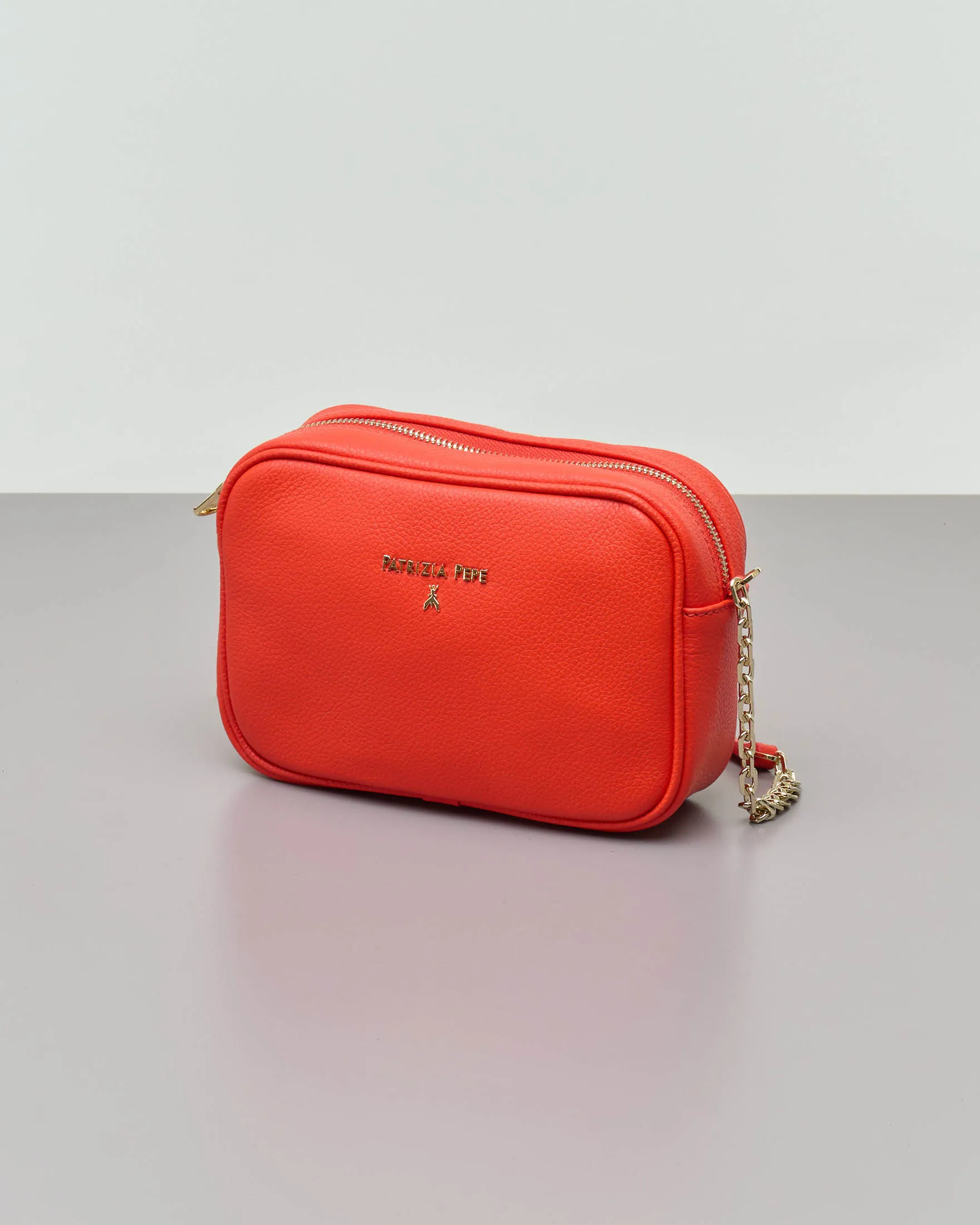 Cross bag arancione in pelle effetto martellato con catena dorata regolabile e scritta logo dorata sul davanti