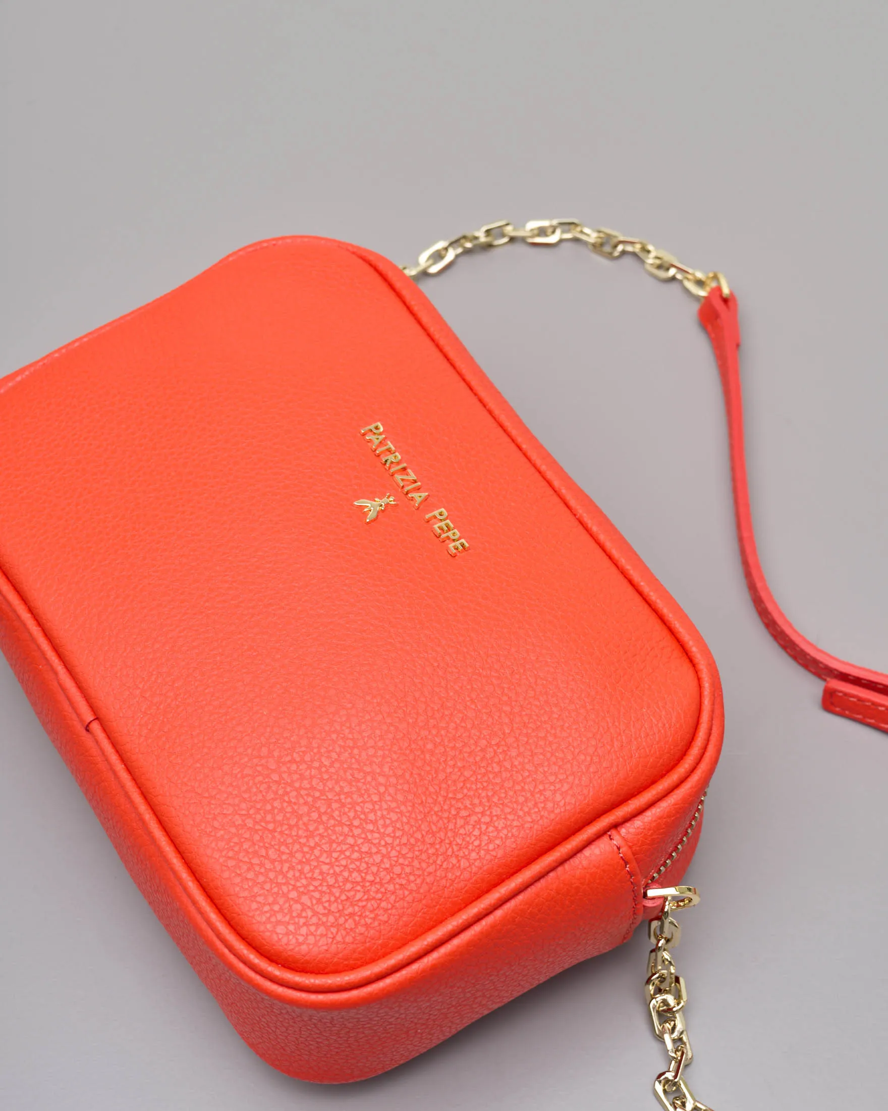 Cross bag arancione in pelle effetto martellato con catena dorata regolabile e scritta logo dorata sul davanti