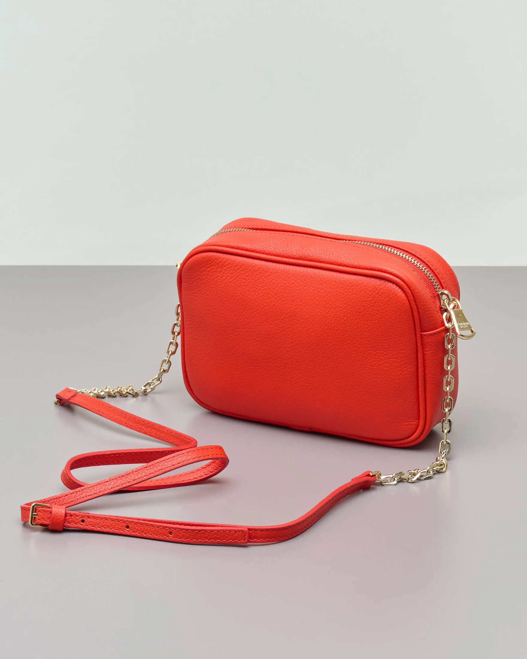 Cross bag arancione in pelle effetto martellato con catena dorata regolabile e scritta logo dorata sul davanti